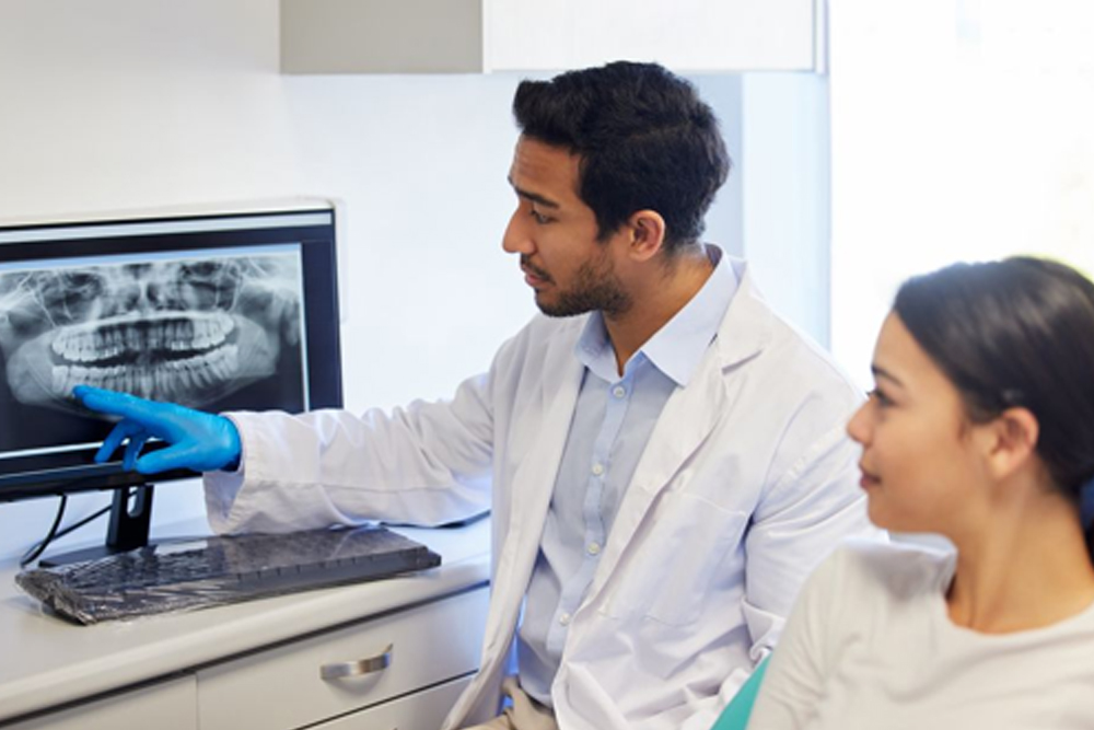 Adult patient speaking with a dentist about an urgent dental concern.